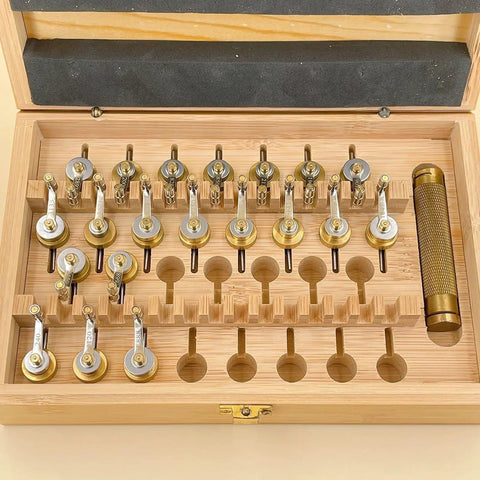 Open wooden box displaying Pro Grade 20 Calibers Watch Mainspring Winder Kit with barrels and copper tools for horology repairs.