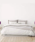 Brushed Steel Stick Table Lamp Set with Charging Outlet and Purple Fabric Shades Two Pack on bedside tables in a modern bedroom.
