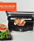 Imusa Electric Panini Press Griddle With Non Stick Cast Aluminum Plates Adjustable Thermostat Control For Gourmet Sandwiches And Toasts Compact Design 1200 Watt Power Heating Element Ideal For Busy Kitchens with sandwiches and fresh ingredients visible.