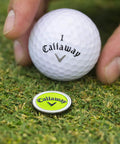Golfer placing ball next to lime magnetic marker from Super Handy Four In One Golf Divot Repair Tool Built With Tough Zinc Alloy.