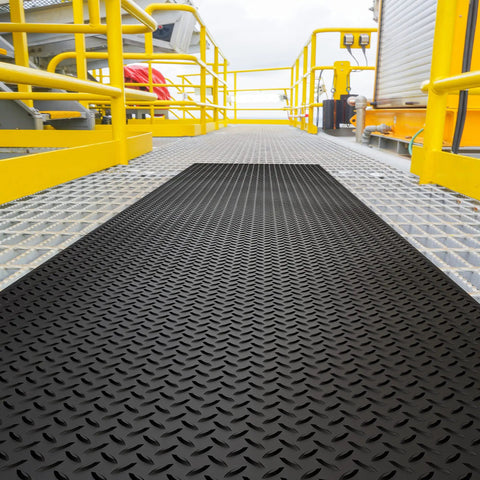 Commercial Grade Vinyl Diamond Plate Floor Mat Knockout Traction Tough As Nails Oil And Chemical Resistant Protection For Heavy Traffic Garages Professional Workshops Black Yellow Border on a metallic platform.