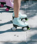 Roller skate brake stoppers toe plugs with screws, green, on blue quad skates on concrete