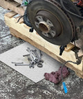Garage scene with an Oil Absorbent Pads 10 x 13 Inch Sheets For Garage And Workshop under car parts and tools