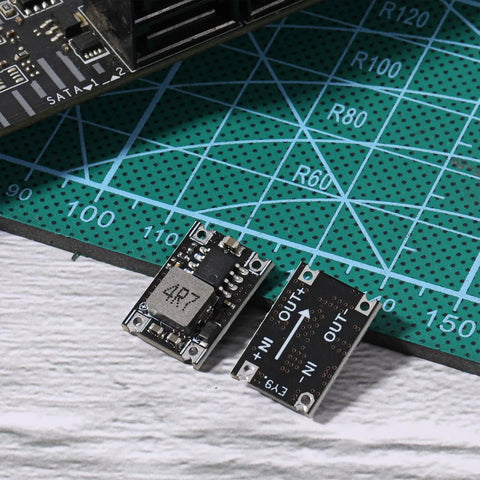 Two Six Pack 5V Buck Converter Modules Set 5V 30V To 5V DC DC Regulator Board MP1584EN on a green cutting mat