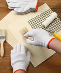 Person wearing 100 Pairs Cotton Liner Gloves For Work And BBQ Roping, Non Slip White Safety Hand Protection, painting a board