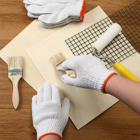 Person wearing 100 Pairs Cotton Liner Gloves For Work And BBQ Roping, Non Slip White Safety Hand Protection, painting a board