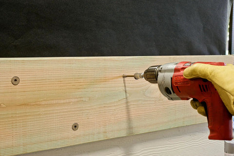 Person using drill with Exterior Grade Timber Screws 0.220 Inch By 4 Inch Double Barrier Coated Washer Head Sawtooth Point on wood