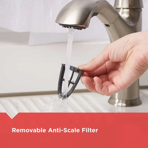Hand holding removable anti-scale filter under running water for cleaning, part of 1.7L Cordless Electric Kettle In Sleek Silver With Automatic Shutoff And Boil Dry Protection No Fuss Easy Pour For Home Kitchen And Office Daily Use Anytime.