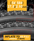 Close-up of 27.5x2.1 inch mountain bike tires with tread and labeling, inflate to 65 PSI, size markings visible.