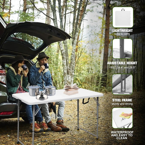 Sturdy 4 Foot Portable Folding Table That Folds In Half, set up near a car in a forest, used for outdoor camping with people.