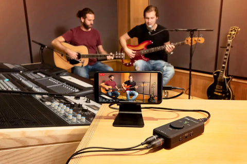 Musicians performing with iRig Stream Stereo Audio Interface For iPhone iPad Mac And PC With USB C Lightning and USB Ports 24 Bit 96 kHz