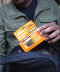 Person packing a Space Grade Emergency Survival Blanket Reflects Over 80 Percent Body Heat Windproof And Waterproof Ultra Durable 3oz Mylar