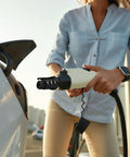 Person using NACS To J1772 EV Charger Adapter For Level 1 And Level 2 Charging, 80 Amps At 250 Volts on electric vehicle.