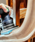 Using Granat Profile Soft Sanding Sheets 80 By 133 Millimeter on curved wooden surface with foam backing for detailed finishing