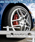 Front-left view of brake line flaring tool kit with dies on silver base, beside blue car wheel with red caliper