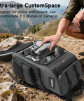 40L Outdoor Drone Backpack With DIY One Piece Partition Ultra Roomy Space For 2 To 3 Drones Or Cameras Fits Mavic 4 Pro Air 3S Avata 360 Mini 5 Pro And Accessories Ready For Any Adventure open on rocky terrain showing compartments and gear