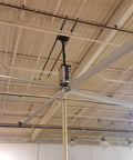 Heavy Duty Twenty Foot Industrial Ceiling Fan Using High Volume Low Speed Technology mounted in a warehouse ceiling.