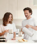 Real Deal Thermal Coffee Carafe Holds Fifty Ounces Advanced Vacuum Insulated Stainless Steel Beverage Dispenser in kitchen with couple.
