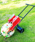 Manual Seed Spreader And Fertilizer Applicator For Garden And Farm Use With Dual Seed And Fertilizer Storage, red, black handle, on grass