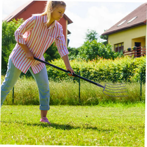 Person using Multi Functional Manure Fork With Iron Construction For Efficient Lawn Maintenance And Gardening in rural area
