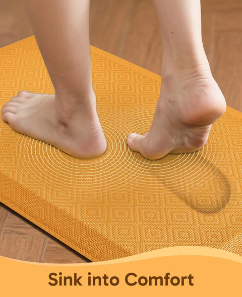 Anti Fatigue Kitchen Mat Cushioned 0.75 Inch Thick Standing Pad For Kitchen Office And Sink 20 By 32 Inches Waterproof Ergonomic Comfort Non Slip Bottom Bright Orange Easy To Clean showing feet pressing into cushioned surface.