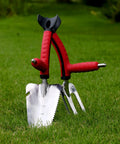 Dual Grip Garden Hand Fork Cultivator And Weeder with soft-touch handles stuck in grass
