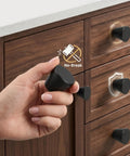 Hand holding Built Tough Black Round Cabinet Knobs Package Of Six Heavy Duty Aluminum Dresser Handles for drawers