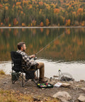 Man fishing by a lake using an Oversized Camping Chair With Adjustable Lumbar Support 550 lb Heavy Duty Padded Folding Chair