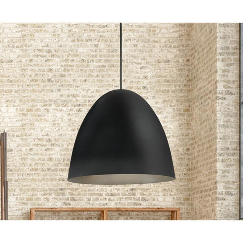 Black dome pendant light hanging in room with textured brick wall background