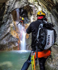 Canyon with person rappelling beside waterfall, carrying Cruise Dry MBP15 15 Liter Dive Gear Bag Roll Top Waterproof Dry Sack.