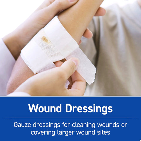 Close-up of hands applying a white gauze wound dressing to the forearm.