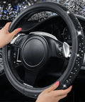 Fresh Bling Diamond Leather Steering Wheel Cover Loaded With Sparkly Crystal Rhinestones Universal Fit For Rides Trucks And SUVs Premium Comfort Grip Accessory For Women with hand gripping on steering wheel.
