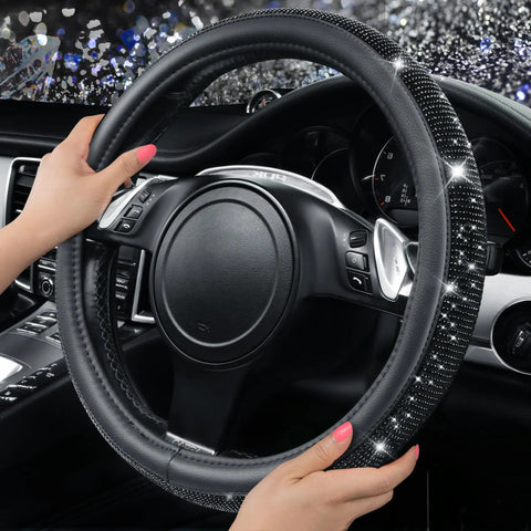 Fresh Bling Diamond Leather Steering Wheel Cover Loaded With Sparkly Crystal Rhinestones Universal Fit For Rides Trucks And SUVs Premium Comfort Grip Accessory For Women with hand gripping on steering wheel.