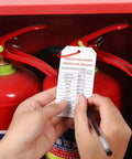 Person recording data on 50 Pack Fire Extinguisher Tags With Adjustable Wire Ties 4 Point 2 By 2 Point 1 Inches Waterproof