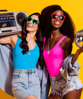 Two women with 70s vibe wearing Mirror Disco Ball Necklaces Set Of 20 Silver Hanging Ornaments For 70s Party, holding boombox and disco ball.