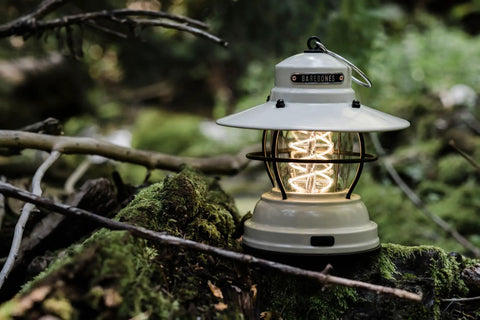 Outpost Lantern With Helix Edison Rope in vintage white, set in a forest setting, highlighting steel body and nostalgic glow.