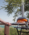 Karu 12 Multi Fuel Outdoor Portable Pizza Oven delivers 950 F heat, cooking 12 inch pizzas in 60 seconds with built-in pizza stone.