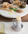 Top Shelf Smooth Spin White Marble Lazy Susan 14 Inch Rolling Turntable For Kitchen Counters And Game Nights with a candle holder.
