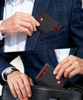 Man placing Ultra Slim RFID Blocking Wallet For Men With 12 Card Capacity, Two ID Windows And Cash Slot in suit pocket and bag