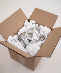 Heavy Duty White Packing Peanuts For Zero Stress Shipping Anti Static S Curve Half Cubic Foot Void Fill cushioning a shiny object in a cardboard box.