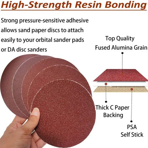 Front view of 6-inch PSA sanding discs with sticky backing; assorted grits (80-400) in red abrasive, held in hand