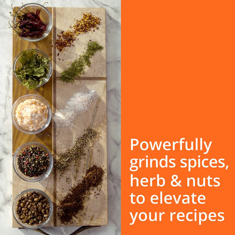 Krups Electric Coffee Grinder With 3 Oz Capacity And 200 Watt Motor grinds spices, herbs, and nuts on a wooden tray.