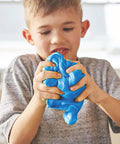 Child playing with blue slime made with Liquid School Glue That Bonds Paper, Wood, Fabric And More, Washable, Safe And Non Toxic.