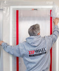 Man installing Red ZipDoor Kit For Dust Protection In Remodeling Jobs Pro Grade Flame Retardant Plastic Door Cover With Preinstalled Zippers