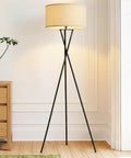LED Floor Lamp Tall Tripod With Drum Shade In Black Finish And Gold Accents in a modern living room setting