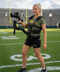 Person wearing Thanos X Gimbal Support Vest System Steadicam Rig for DJI RS4 Pro RS3 RS2 on a sports field
