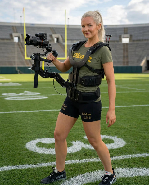Person wearing Thanos X Gimbal Support Vest System Steadicam Rig for DJI RS4 Pro RS3 RS2 on a sports field