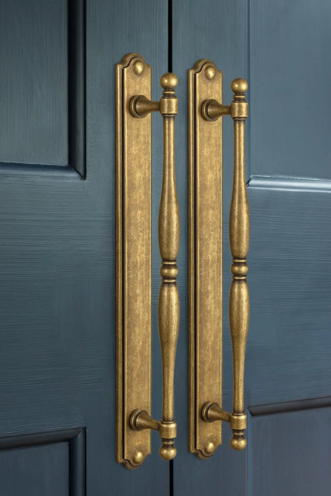 Vintage Spindle Style 2 Pack Antique Brass Cabinet Pulls With Backplates, Distressed Finish installed on blue cabinet doors