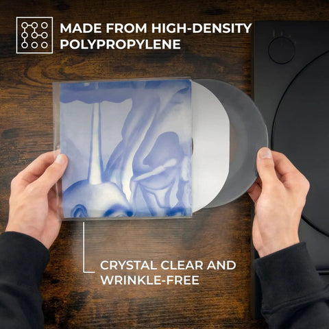 Hands inserting vinyl into Crystal Clear 3 Mil 7 Inch Vinyl Outer Sleeves Pack 100 Count Durable Polypropylene Covers for LPs and Singles