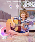 Rechargeable Dimmable Moon Lamp With Bluetooth App Control And RGB Color Changing Light For Kids next to child with guitar